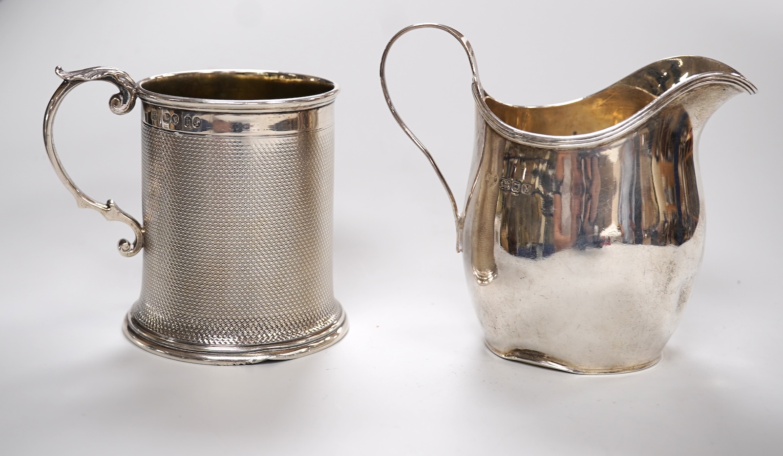 A Victorian engine turned silver christening mug by John Samuel Hunt (Hunt & Roskell), London, 1863, with later engraved inscription to the base, height 89mm, together with a George VI silver cream jug, London, 1947, 12o